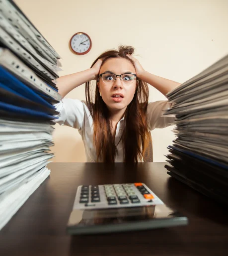 Woman being stressed out by piles of paperwork in front of her